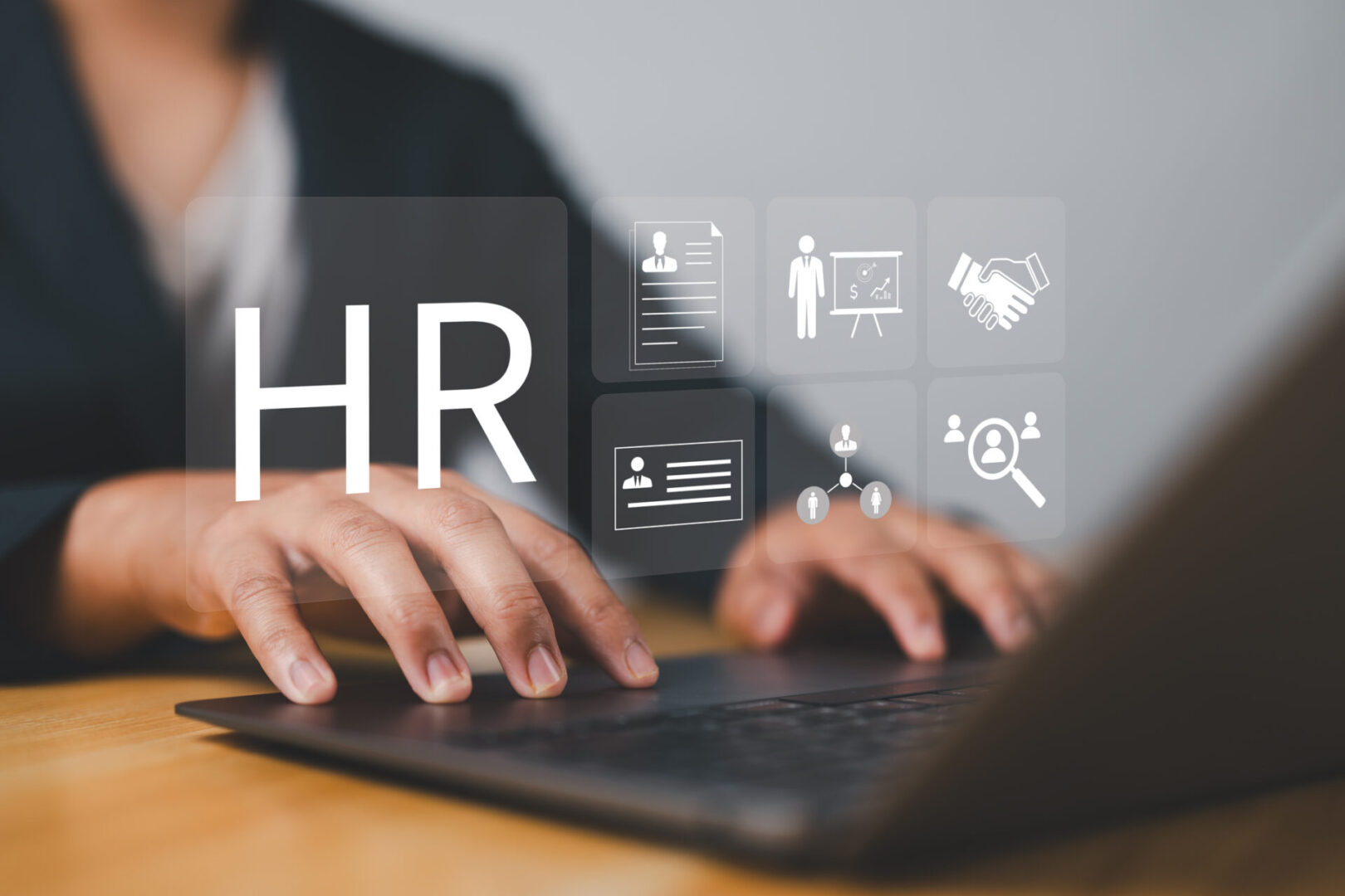 Human resources professional using laptop with HR icons