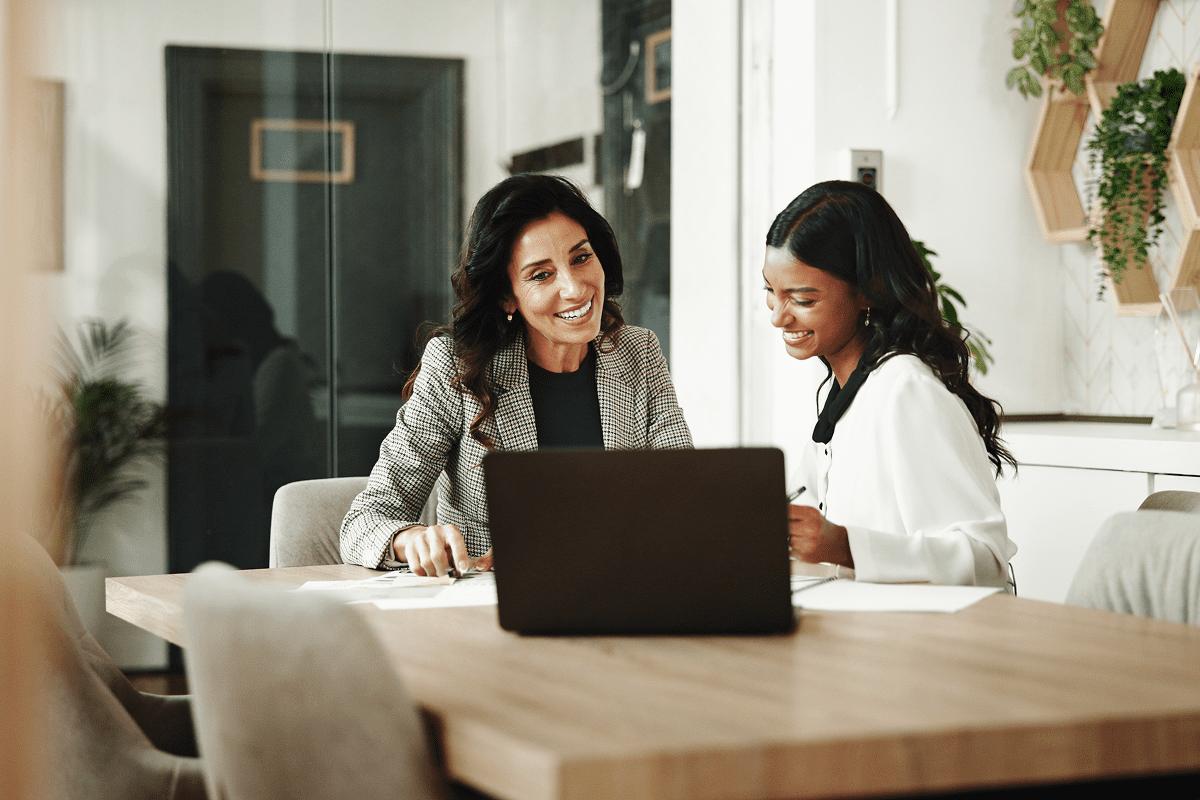 Two professional women collaborating on laptop