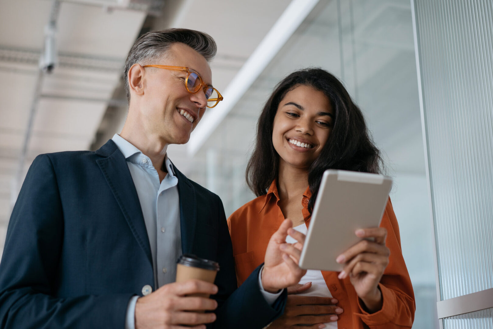 Smiling coworkers viewing tablet in office